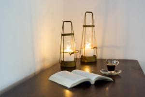 una mesa con dos lámparas y un libro y una taza de café en Reflection Cave House, en Pirgos 14 fotos más