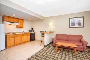 a living room with a couch and a kitchen at Baymont by Wyndham Hays in Hays +19 photos