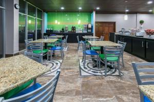 a restaurant with tables and chairs and a kitchen at Super 8 by Wyndham Ft Stockton in Fort Stockton