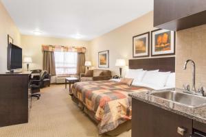 una habitación de hotel con una cama y un lavabo en Ramada by Wyndham Pincher Creek, en Pincher Creek 31 fotos más
