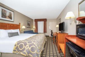 a hotel room with a bed and a flat screen tv at Baymont by Wyndham Hays in Hays