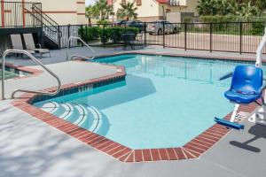 a swimming pool with a blue chair in a apartment at Super 8 by Wyndham Brenham TX in Brenham