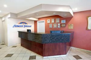 a hotel lobby with a front desk with a sign at Howard Johnson by Wyndham Red Deer in Red Deer
