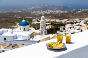 un bol de fruta y dos vasos de cerveza en una cornisa en Reflection Cave House, en Pirgos