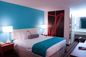 1 dormitorio con 1 cama grande y pared azul en Howard Johnson by Wyndham Salinas, en Salinas
