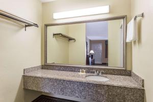 baño con lavabo y espejo grande en Days Inn by Wyndham Orange en Orange