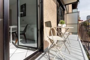 a patio with a table and chairs on a balcony at Deluxe Apartments Friedrichstrasse in Freiburg im Breisgau
