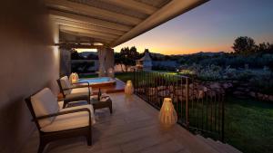 a patio with chairs and a table on a deck at Destino di Nora in Pula