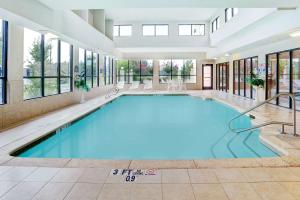 a large swimming pool in a building with windows at Wingate by Wyndham Atlanta Fairburn in Fairburn