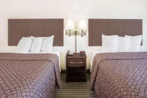 Habitación de hotel con 2 camas y mesa con 2 lámparas en Super 8 by Wyndham Cedar Falls, en Cedar Falls