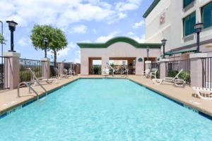 a swimming pool at a hotel with chairs and a building at Wingate by Wyndham Yuma in Yuma