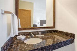 a bathroom with a sink and a mirror at Super 8 by Wyndham Cedar Falls in Cedar Falls