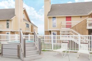 una terraza con 2 sillas y una casa en Hawthorn Suites Wichita East, en Wichita