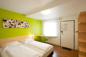 1 dormitorio con cama blanca y pared verde en City Motel Soest, en Soest