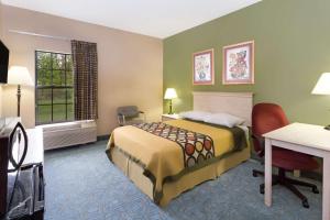 una camera d'albergo con letto, scrivania e finestra di Super 8 by Wyndham Freeport a Freeport