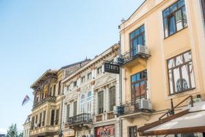 un edificio alto de color amarillo con balcones en una calle en Somnia en Bitola