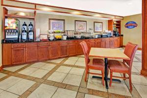 a kitchen with a table and chairs and a counter at Baymont by Wyndham Indianapolis West in Indianapolis
