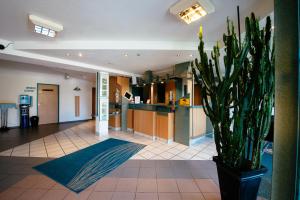 eine Topfpflanze in der Mitte einer Lobby in der Unterkunft Hotel Residenz in Schnelldorf