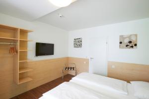 sypialnia z łóżkiem i telewizorem na ścianie w obiekcie City Motel Soest w mieście Soest