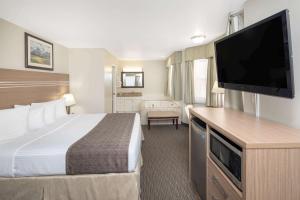 Säng eller sängar i ett rum på Travelodge by Wyndham Golden Sportsman Lodge