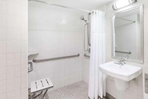 a white bathroom with a sink and a shower at Wyndham Pittsburgh University Center in Pittsburgh