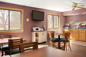 a kitchen with a dining room with a table and chairs at Baymont by Wyndham Logan in Logan