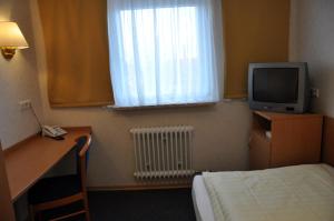 a bedroom with a television and a bed at Hotel Bürgerhof in Homburg