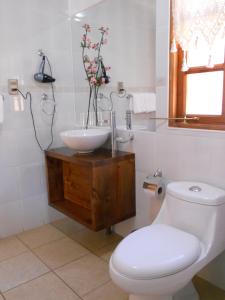 La salle de bains est pourvue de toilettes blanches et d'un lavabo. dans l'établissement L'Emiliano Cabañas-Ristorante, à Capitán Pastene
