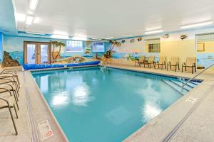 a large swimming pool with chairs and a swimming pool at Super 8 by Wyndham Gurnee in Gurnee