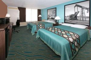 ein Hotelzimmer mit zwei Betten und einem Fernseher in der Unterkunft Super 8 by Wyndham Duncan in Duncan