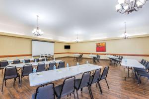 une salle de conférence avec des tables et des chaises et un tableau blanc dans l'établissement Super 8 by Wyndham Clovis, à Clovis