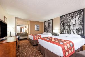 a hotel room with two beds and a flat screen tv at Super 8 by Wyndham Clovis in Clovis
