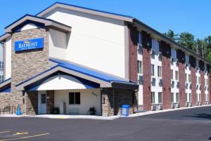 a large brick building with a blue sign on it at Baymont by Wyndham Stevens Point in Stevens Point