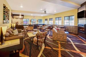 a restaurant with couches and tables and a bar at Super 8 by Wyndham Akron S/Green/Uniontown OH in Uniontown