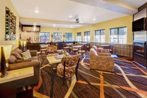 un restaurant avec des canapés, des tables et un bar dans l'établissement Super 8 by Wyndham Akron S/Green/Uniontown OH, à Uniontown