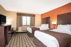 Un pat sau paturi într-o cameră la Baymont by Wyndham Lakeville +28 fotografii