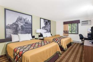 a hotel room with two beds and a desk at Super 8 by Wyndham Eau Claire I-94 in Eau Claire