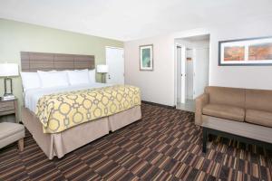 a hotel room with a bed and a chair at Baymont by Wyndham Plano in Plano +61 photos