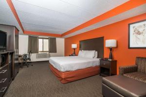 a hotel room with a bed and a television at Baymont by Wyndham Bloomington MSP Airport in Richfield