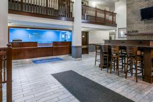 a lobby with a bar with stools and a tv at Baymont by Wyndham Bloomington MSP Airport in Richfield