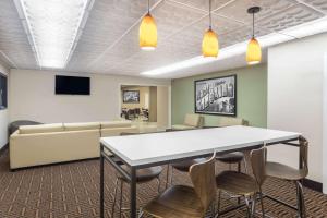Super 8 by Wyndham Asheville Airport في فليتشر: قاعة اجتماعات مع طاولة وكراسي وأريكة