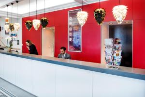 a man and a woman sitting at a counter in a restaurant at H&ocirc;tel Sainte-Rose in Lourdes