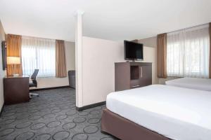a hotel room with a bed and a flat screen tv at Baymont by Wyndham San Diego Downtown in San Diego