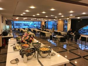 台南的住宿－日升大飯店，一间设有桌子的餐厅,有坐在桌子上的人