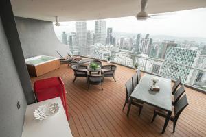 a balcony with tables and chairs and a view of a city at The Penthouse KLCC - Suite & Duplex 57F Sky Residence in Kuala Lumpur