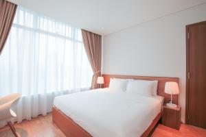 a bedroom with a white bed and a large window at The Penthouse KLCC in Kuala Lumpur