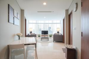 a dining room with a table and a living room at The Penthouse KLCC - Suite & Duplex 57F Sky Residence in Kuala Lumpur