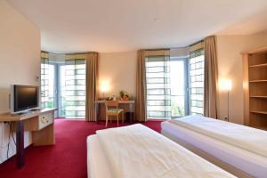 pokój hotelowy z 2 łóżkami i telewizorem w obiekcie Hotel Aspethera w mieście Paderborn
