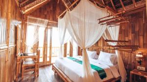 a bedroom with a bed and a canopy at Penida Bambu Green in Nusa Penida
