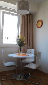 een tafel en stoelen met een vaas met bloemen erop bij Natalija Twister Apartment in Budva